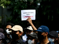 Students hold protest posters during a demonstration to reject the ratification of the Regional Head Election (Pilkada) Bill in front of the...