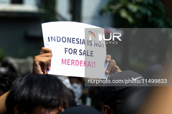 Students hold protest posters during a demonstration to reject the ratification of the Regional Head Election (Pilkada) Bill in front of the...