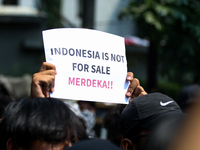 Students hold protest posters during a demonstration to reject the ratification of the Regional Head Election (Pilkada) Bill in front of the...