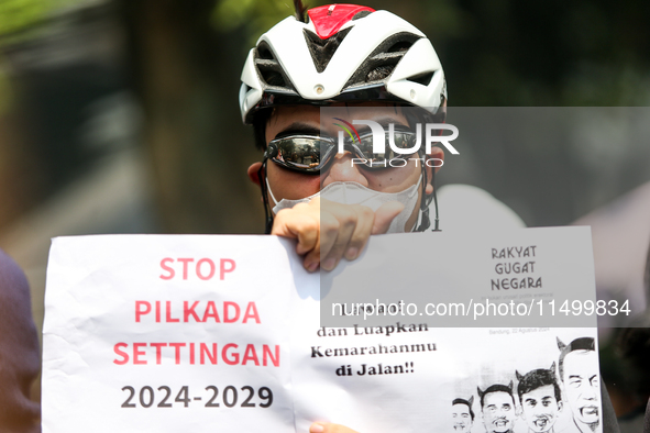 Students hold protest posters during a demonstration to reject the ratification of the Regional Head Election (Pilkada) Bill in front of the...