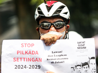 Students hold protest posters during a demonstration to reject the ratification of the Regional Head Election (Pilkada) Bill in front of the...