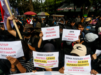 Students hold protest posters during a demonstration to reject the ratification of the Regional Head Election (Pilkada) Bill in front of the...