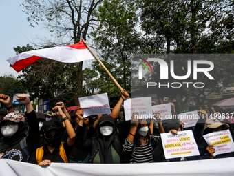 Students hold protest posters during a demonstration to reject the ratification of the Regional Head Election (Pilkada) Bill in front of the...