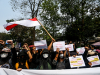 Students hold protest posters during a demonstration to reject the ratification of the Regional Head Election (Pilkada) Bill in front of the...