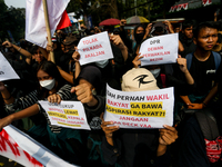 Students hold protest posters during a demonstration to reject the ratification of the Regional Head Election (Pilkada) Bill in front of the...