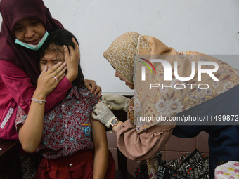 A health worker injects a dose of the Human Papilloma Virus (HPV) vaccine into a schoolgirl's arm during the Immunization Month for School C...