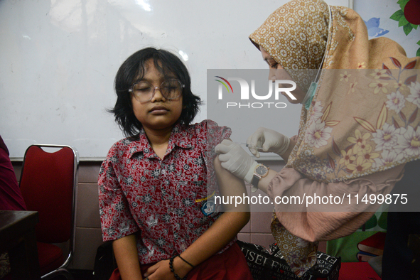 A health worker injects a dose of the Human Papilloma Virus (HPV) vaccine into a schoolgirl's arm during the Immunization Month for School C...