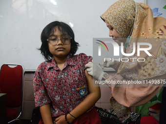 A health worker injects a dose of the Human Papilloma Virus (HPV) vaccine into a schoolgirl's arm during the Immunization Month for School C...