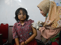 A health worker injects a dose of the Human Papilloma Virus (HPV) vaccine into a schoolgirl's arm during the Immunization Month for School C...