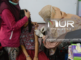 A schoolgirl receives a dose of the Human Papilloma Virus (HPV) vaccine during the Immunization Month for School Children (BIAS) 2024 at an...