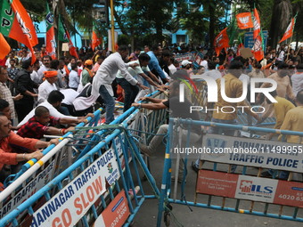 Bharatiya Janata Party (BJP) participates in a protest rally marching to the Health Headquarters and crosses the police barricade in protest...