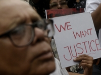 Artist professionals shout slogans and hold placards as part of a protest against the rape and murder of a trainee medic at a government-run...