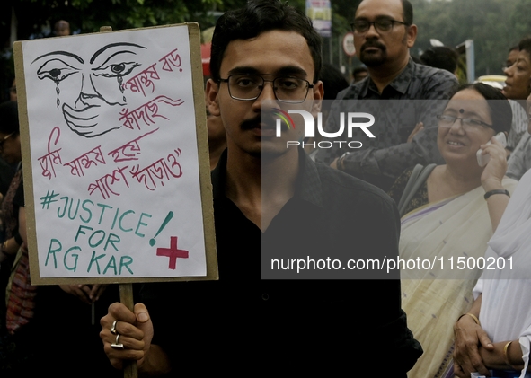 Artist professionals shout slogans and hold placards as part of a protest against the rape and murder of a trainee medic at a government-run...