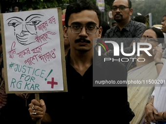 Artist professionals shout slogans and hold placards as part of a protest against the rape and murder of a trainee medic at a government-run...