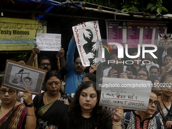 Artist professionals shout slogans and hold placards as part of a protest against the rape and murder of a trainee medic at a government-run...