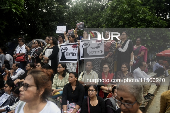 Artist professionals shout slogans and hold placards as part of a protest against the rape and murder of a trainee medic at a government-run...