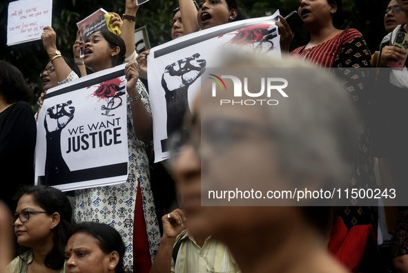 Artist professionals shout slogans and hold placards as part of a protest against the rape and murder of a trainee medic at a government-run...