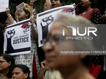 Artist professionals shout slogans and hold placards as part of a protest against the rape and murder of a trainee medic at a government-run...