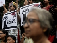 Artist professionals shout slogans and hold placards as part of a protest against the rape and murder of a trainee medic at a government-run...