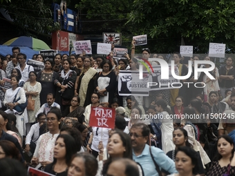 Artist professionals shout slogans and hold placards as part of a protest against the rape and murder of a trainee medic at a government-run...