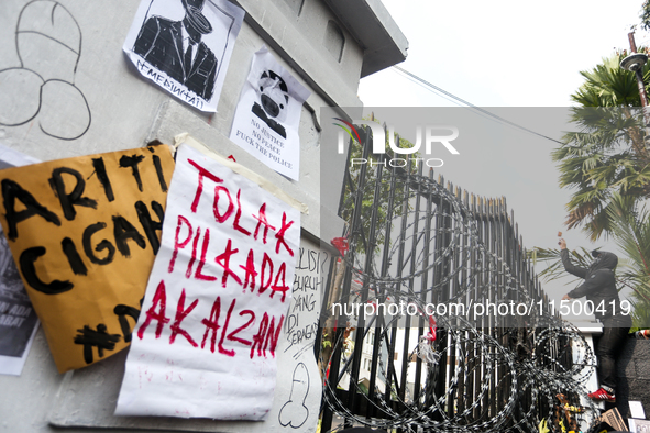 A mob throws stones during a protest against the revision of the Regional Head Election Bill (RUU) in front of the West Java DPRD Building i...