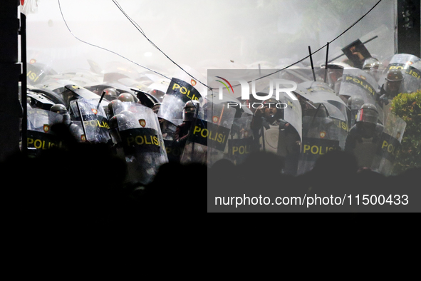 Thousands of demonstrators clash with police during a protest against the revision of the Regional Head Election Bill (RUU) in front of the...