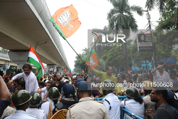 Bharatiya Janata Party (BJP) activists shout slogans and try to break the police barricade during a protest rally as they go towards the Sta...