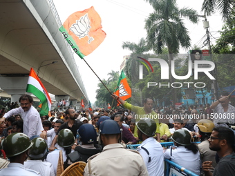 Bharatiya Janata Party (BJP) activists shout slogans and try to break the police barricade during a protest rally as they go towards the Sta...