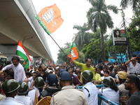 Bharatiya Janata Party (BJP) activists shout slogans and try to break the police barricade during a protest rally as they go towards the Sta...