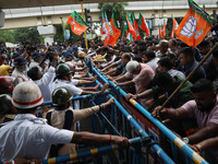 Bharatiya Janata Party (BJP) activists shout slogans and try to break the police barricade during a protest rally as they go towards the Sta...