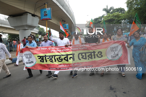 Bharatiya Janata Party (BJP) activists shout slogans after breaking the police barricade during a protest rally as they go towards the State...