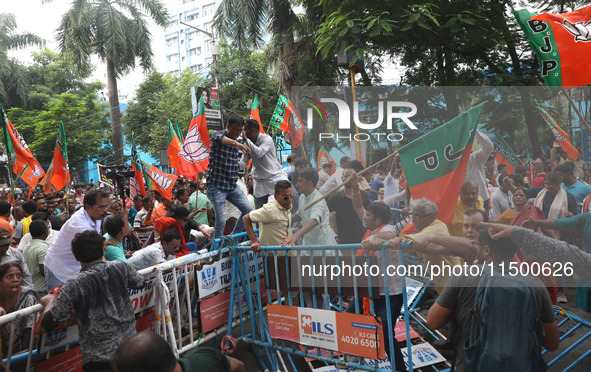 Bharatiya Janata Party (BJP) activists shout slogans and break the police barricade during a protest rally as they go towards the State Heal...