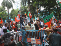 Bharatiya Janata Party (BJP) activists shout slogans and break the police barricade during a protest rally as they go towards the State Heal...