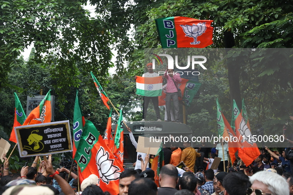 Bharatiya Janata Party (BJP) activists shout slogans and break the police barricade during a protest rally as they go towards the State Heal...