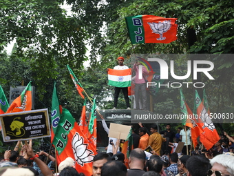 Bharatiya Janata Party (BJP) activists shout slogans and break the police barricade during a protest rally as they go towards the State Heal...