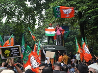 Bharatiya Janata Party (BJP) activists shout slogans and break the police barricade during a protest rally as they go towards the State Heal...