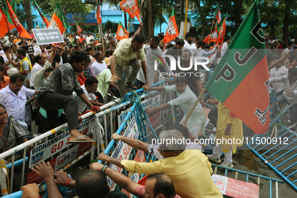 Bharatiya Janata Party (BJP) activists break the police barricade during a protest rally as they go towards the 'Swasthya Bhawan' or State H...