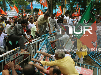 Bharatiya Janata Party (BJP) activists break the police barricade during a protest rally as they go towards the 'Swasthya Bhawan' or State H...