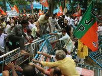 Bharatiya Janata Party (BJP) activists break the police barricade during a protest rally as they go towards the 'Swasthya Bhawan' or State H...