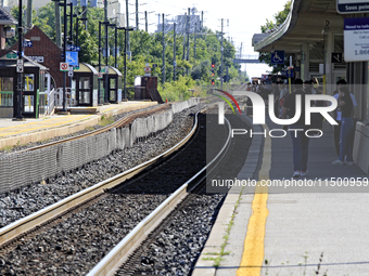 Pedestrians wait for passenger commuter trains on the same rail corridor through the Brampton Innovation District that Canadian National Rai...