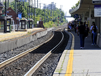 Pedestrians wait for passenger commuter trains on the same rail corridor through the Brampton Innovation District that Canadian National Rai...