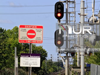 Red signal lights show at a level crossing on the same rail corridor through the Brampton Innovation District that Canadian National Railway...