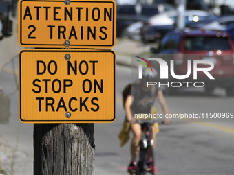 A bicyclist rides toward a level crossing at the rail corridor through the Brampton Innovation District that Canadian National Railway opera...