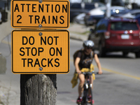 A bicyclist rides toward a level crossing at the rail corridor through the Brampton Innovation District that Canadian National Railway opera...