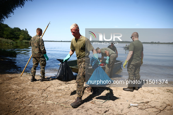 Members of Territorial Defence Force remove dead fishes from Lake Dzierzno Duze in Rzeczyce, southern Poland on August 20th, 2024. Since the...