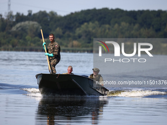 Members of Territorial Defence Force are seen on a boat after removing dead fishes from Lake Dzierzno Duze in Rzeczyce, southern Poland on A...