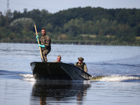 Members of Territorial Defence Force are seen on a boat after removing dead fishes from Lake Dzierzno Duze in Rzeczyce, southern Poland on A...