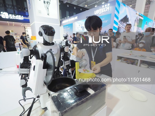 Visitors visit a ''stir-frying robot'' at the 2024 World Robot Conference in Beijing, China, on August 22, 2024. 