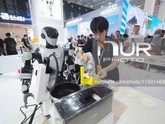 Visitors visit a ''stir-frying robot'' at the 2024 World Robot Conference in Beijing, China, on August 22, 2024. (