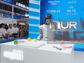 Visitors watch a robot grasping performance at the 2024 World Robot Conference in Beijing, China, on August 22, 2024. (